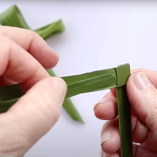 Wrapping the palm frond to create a square